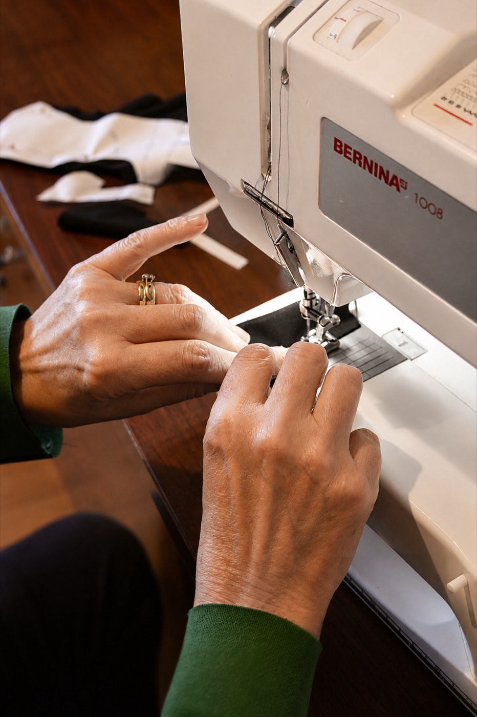 Close-up of hands stitching fabric on a sewing machine